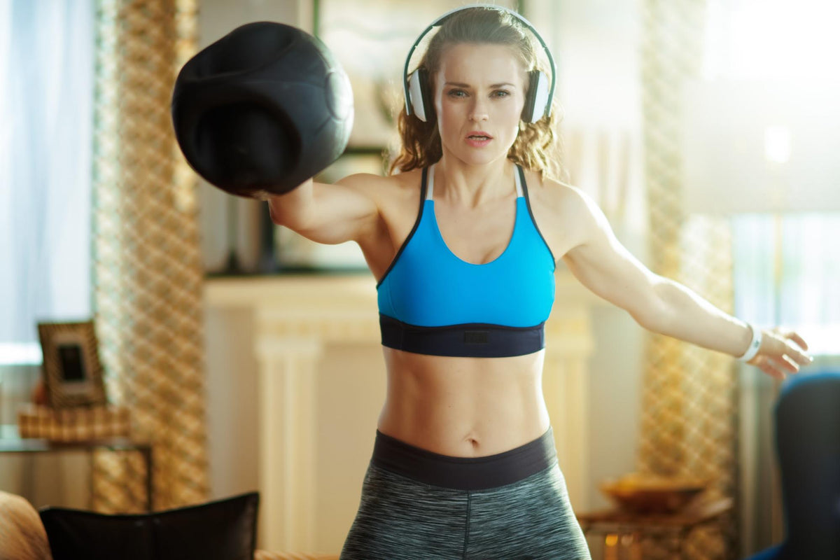 A woman does kettlebell workouts at home