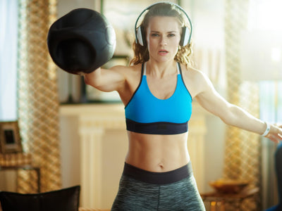 A woman does kettlebell workouts at home