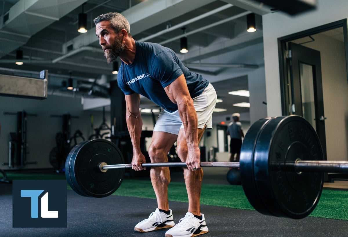 Lower back workouts: Man lifts a barbell in a deserted building