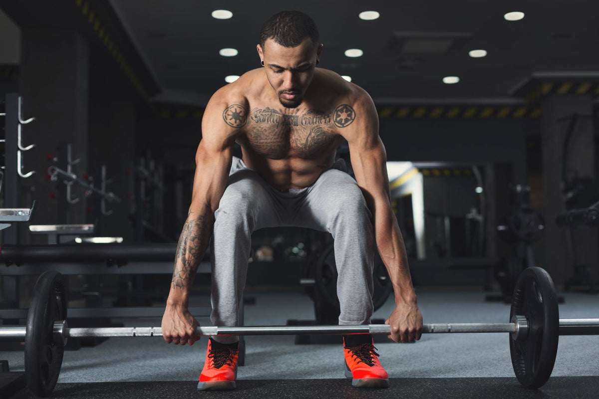 Man deadlifting as part of hamstring exercises