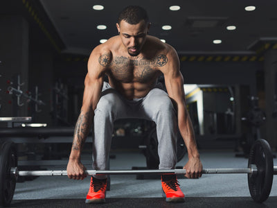 Man deadlifting as part of hamstring exercises