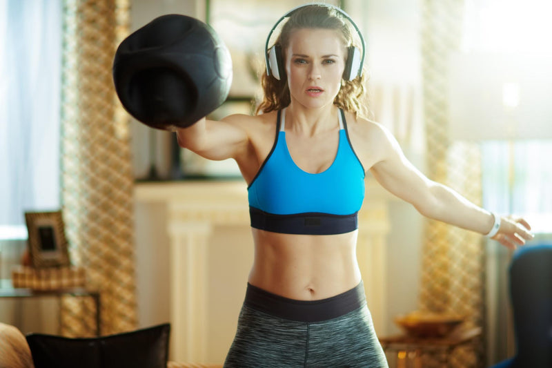 A woman does kettlebell workouts at home