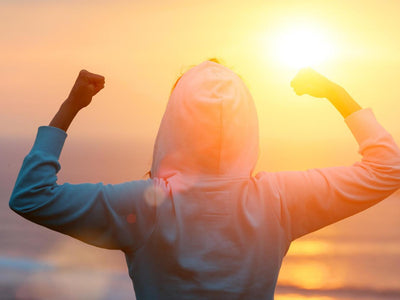 Workout motivation: Back view of strong woman towards the sun