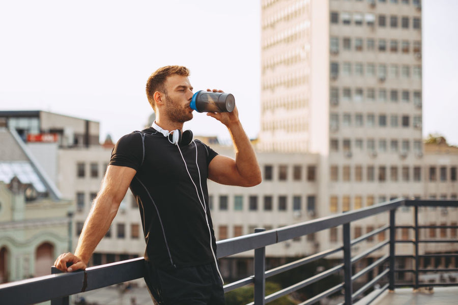 Man drinking post-workout shake on a rooftop