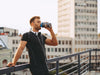 Man drinking post-workout shake on a rooftop